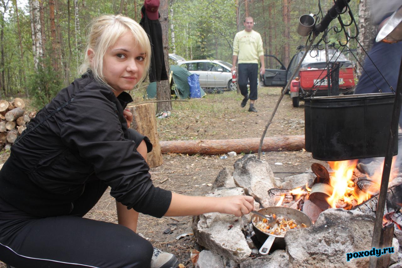 Девушка готовит обед в котелке на костре
