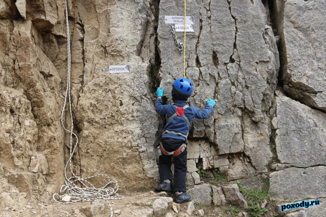 Ребенок готовится лезть на отвесную стену Дюкинского карьера