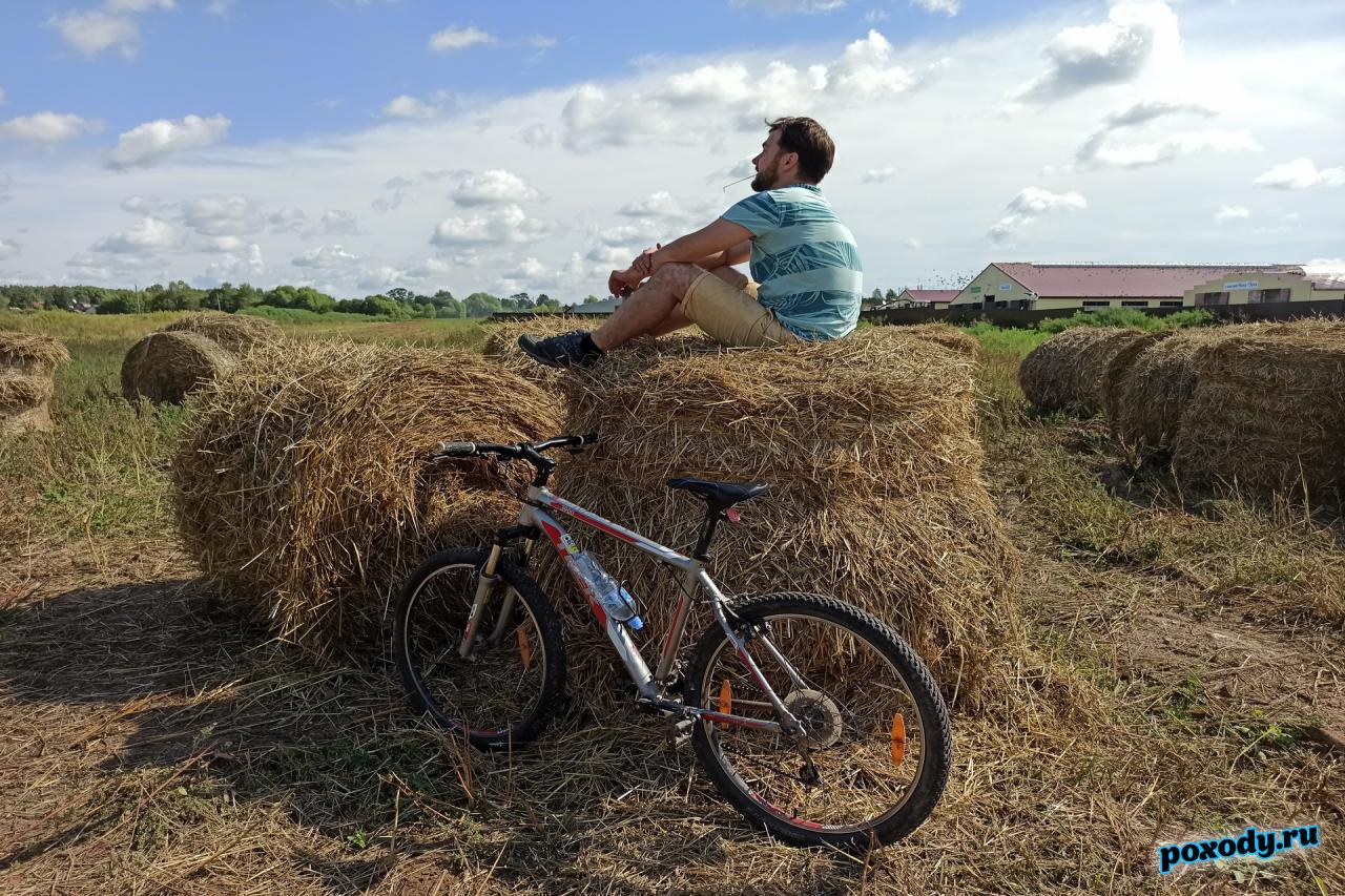 Велосипедист отдыхает на стоге сена